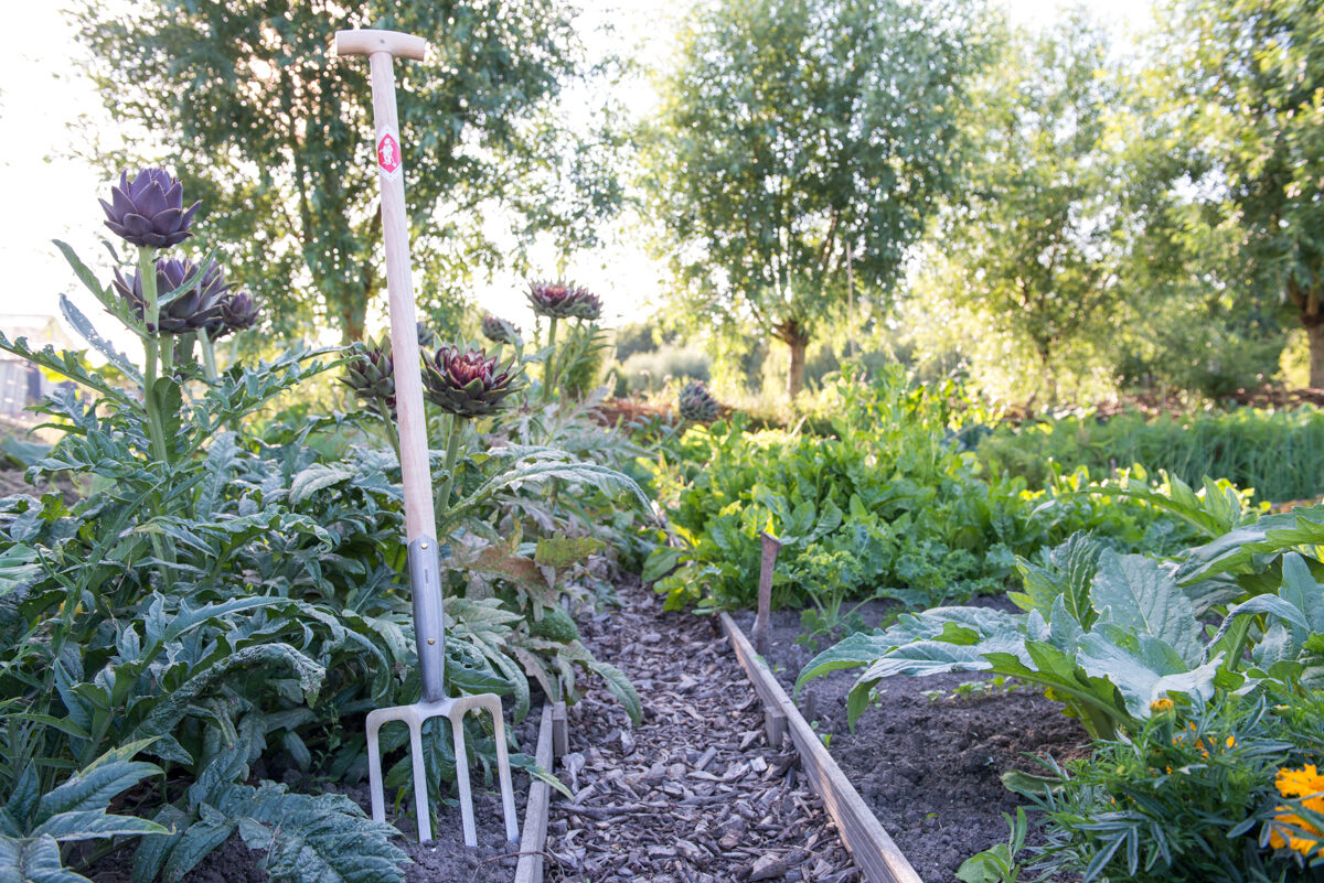 Handgesmede tuinvork van Sneeboer in de zomertuin