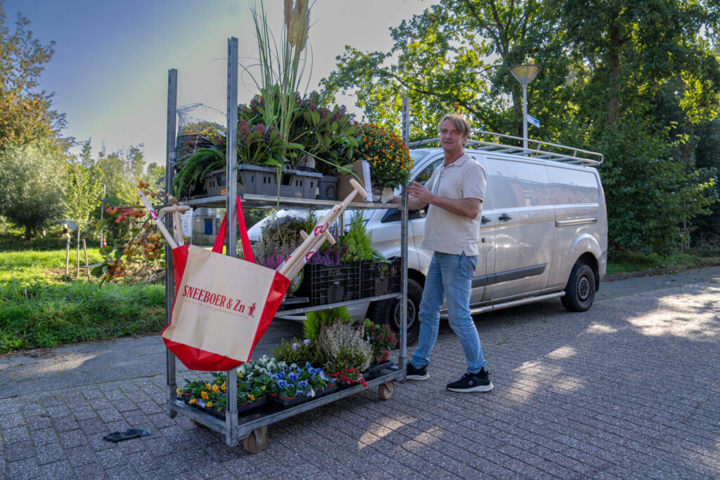 Plantenkar met violen, heide en coniferen en een Sneeboer-tas voor de plantactie